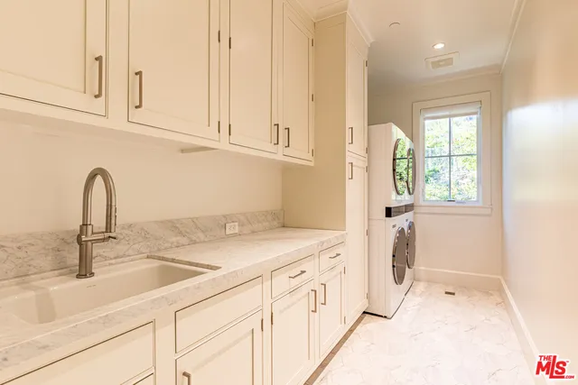 a kitchen with stainless steel appliances granite countertop a sink and dishwasher with white cabinets