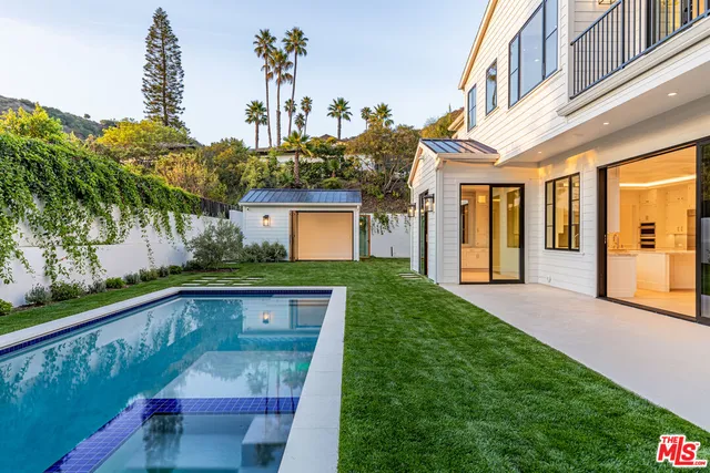 a view of a house with backyard and sitting area