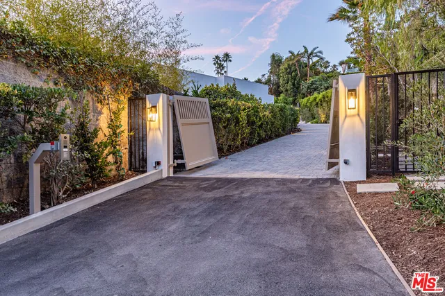 a view of a road with plants and trees beside of it