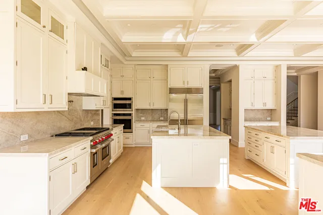 a kitchen with stainless steel appliances kitchen island granite countertop a stove and a refrigerator