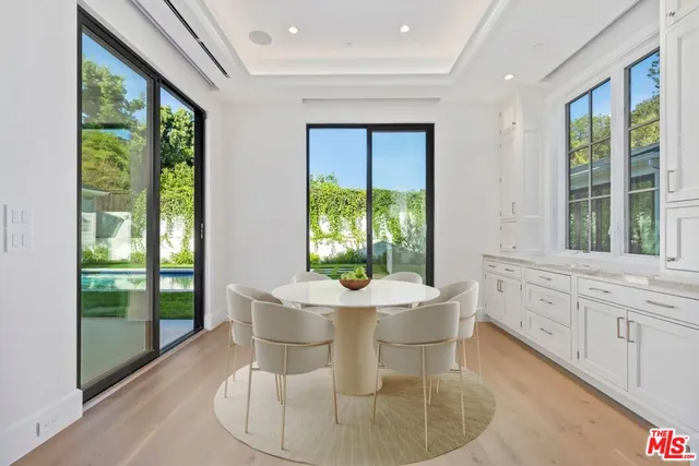 a dining room with furniture a chandelier and wooden floor