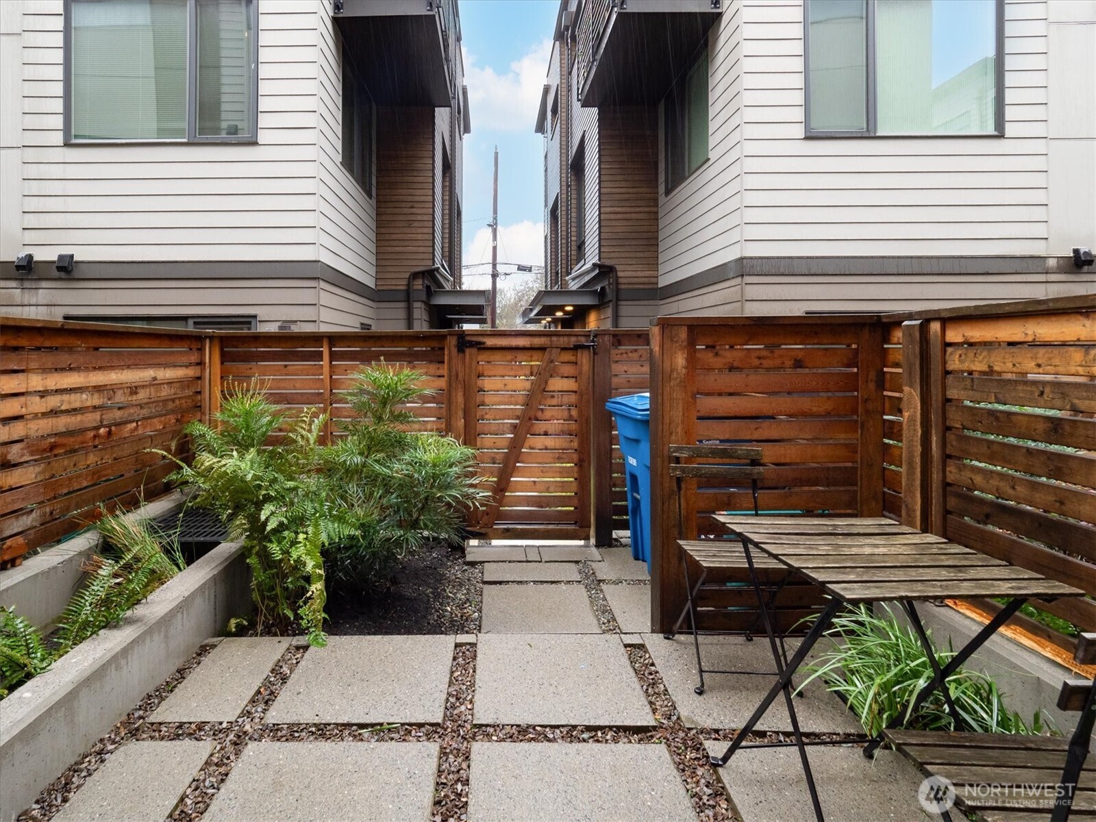 6309 9th Avenue Northeast, Unit D Seattle, WA 98115 - Photo 7 of 28 a view of a patio with a table and chairs and potted plants