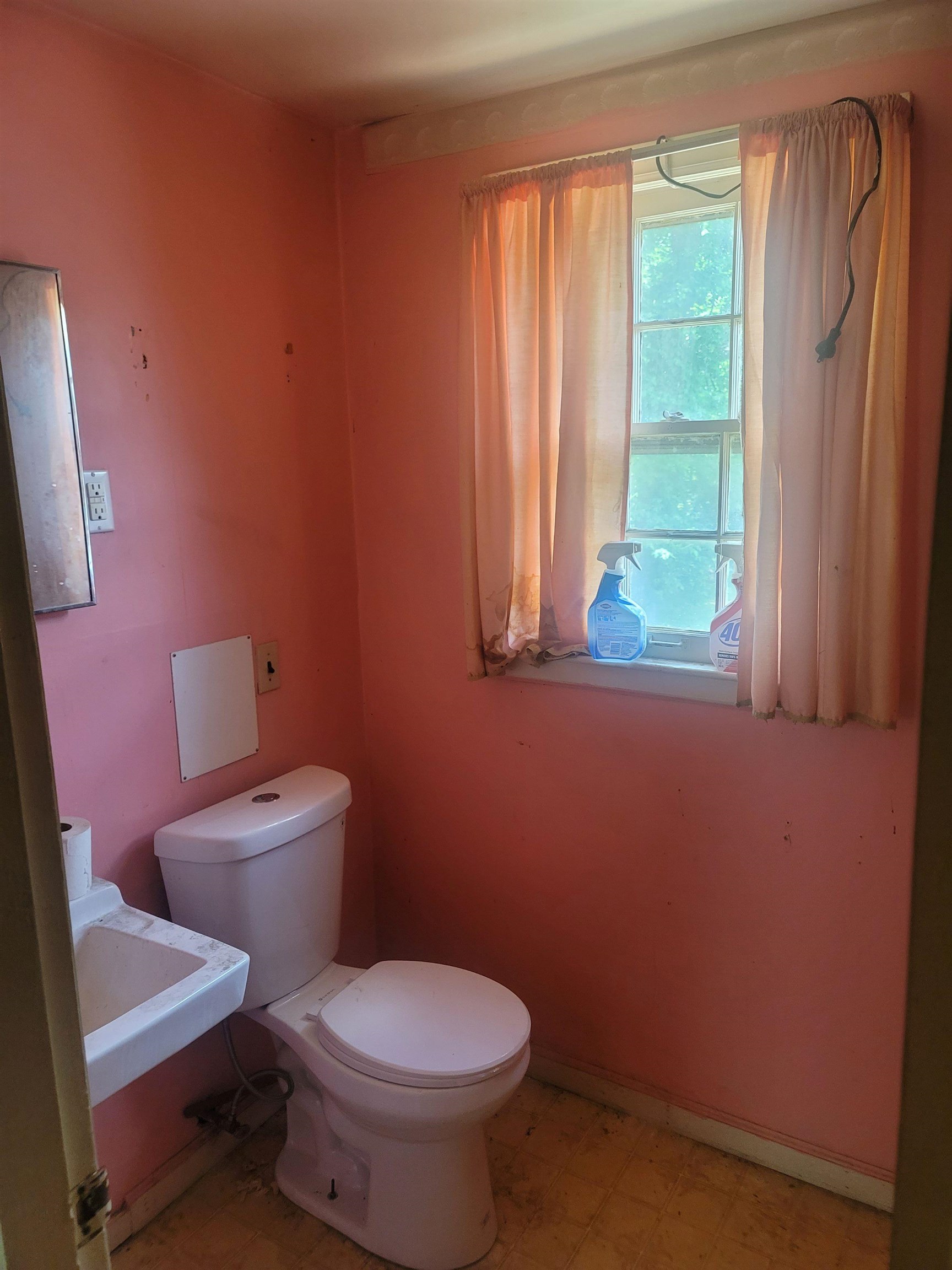 516 East Raines Road Memphis, TN 38109 - Photo 15 of 34 a white toilet sitting in a bathroom next to a window