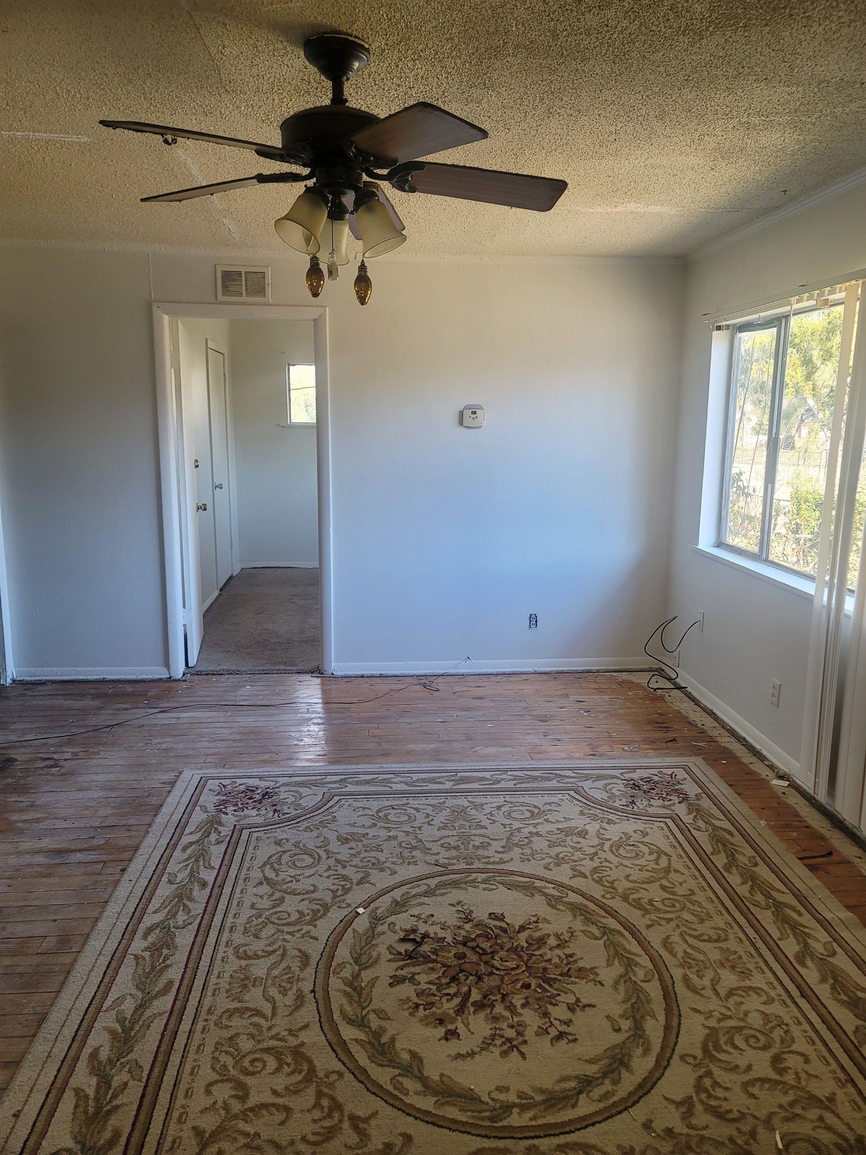 516 East Raines Road Memphis, TN 38109 - Photo 21 of 34 Spare room with hardwood / wood-style flooring, ceiling fan, and a textured ceiling