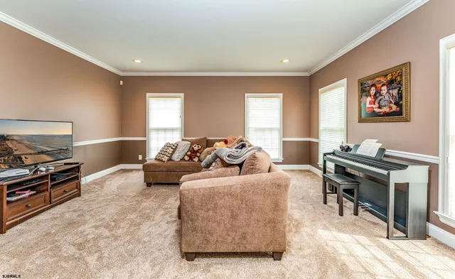 a living room with furniture a flat screen tv and a window