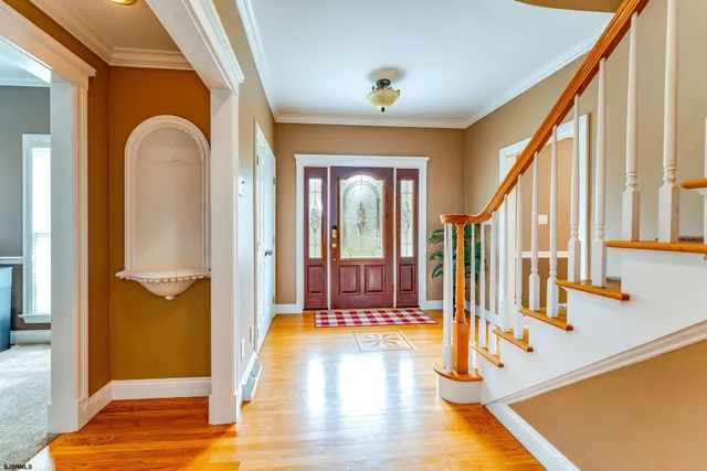 a view of a hallway with wooden floor and stairs
