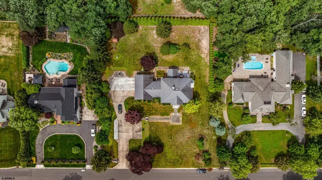 an aerial view of a house with a yard and lake view