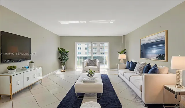 a living room with furniture a table and a large window