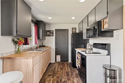 a kitchen with stainless steel appliances granite countertop a refrigerator a stove a sink and a microwave