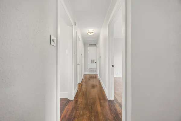 a view of a hallway with wooden floor and closet