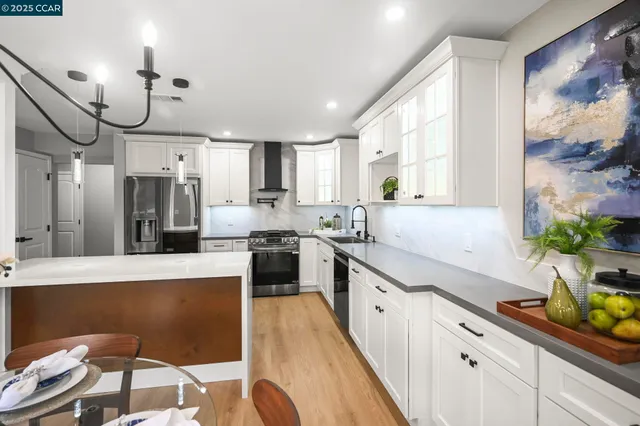 a large kitchen with stainless steel appliances granite countertop a lot of counter space and wooden floors