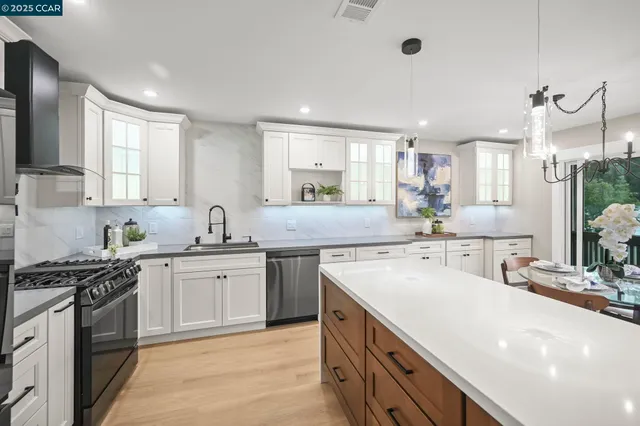 a kitchen with stainless steel appliances a sink stove and cabinets