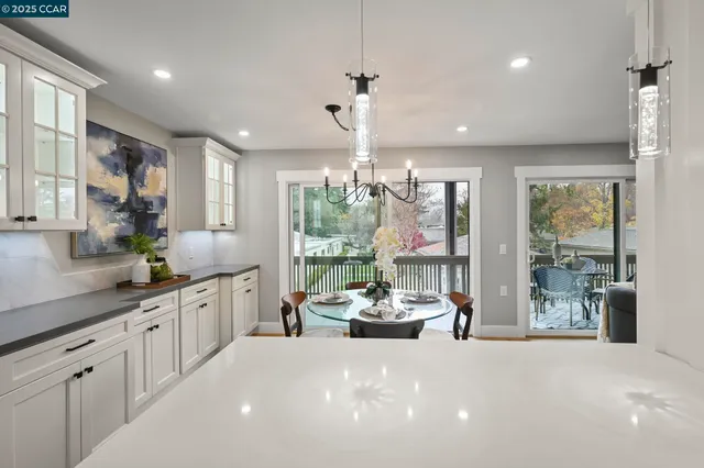 a large white kitchen with large windows and white appliances