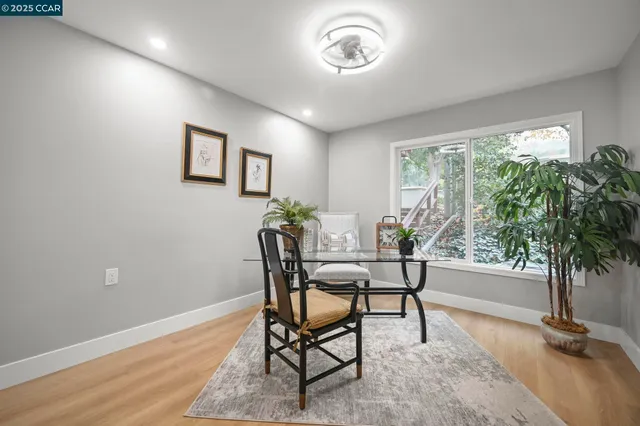 a dining room with furniture and potted plants