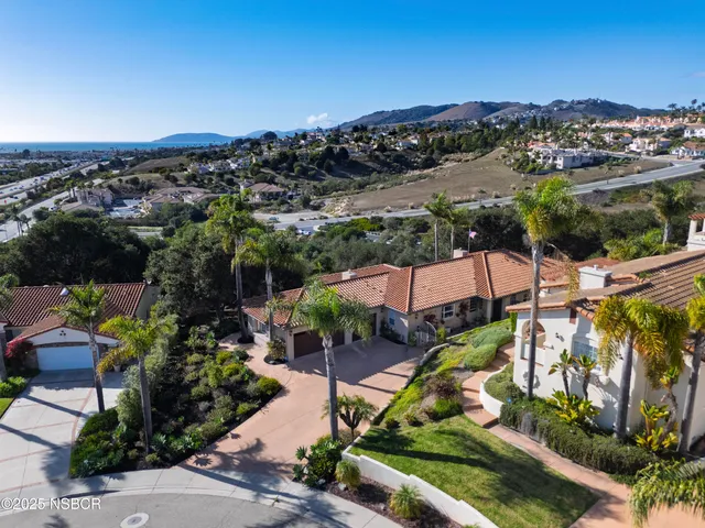 an aerial view of residential houses with outdoor space and ocean view