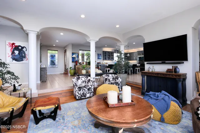 a living room with furniture a flat screen tv and kitchen view