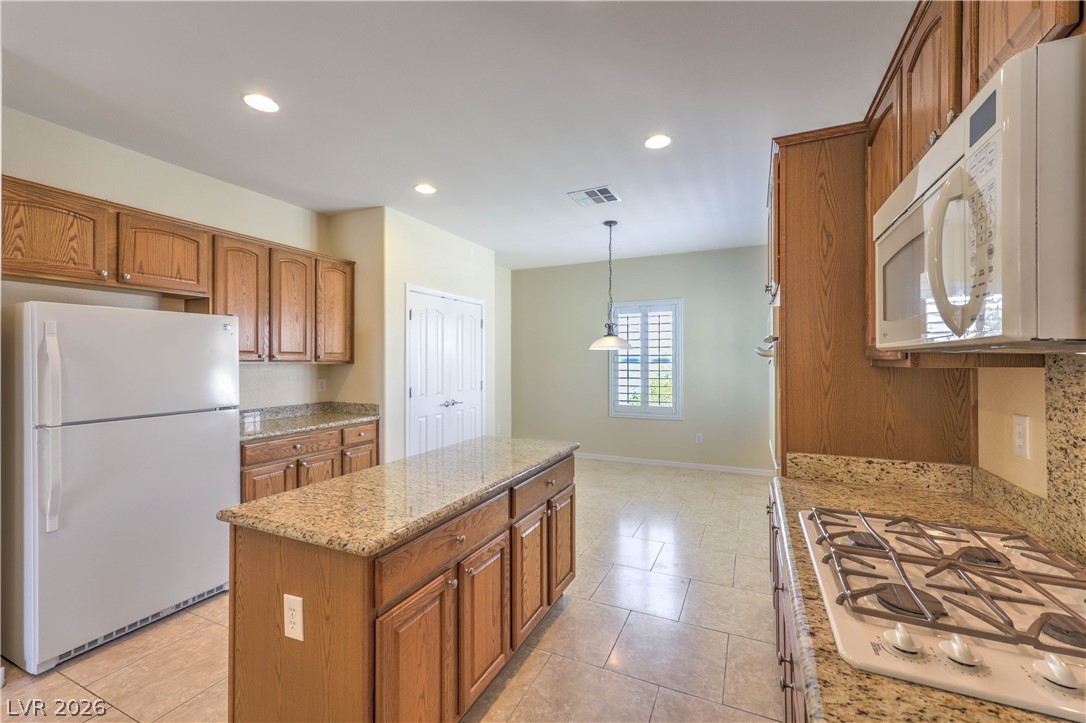 2276 Saxtons River Road Henderson, NV 89044 - Photo 10 of 49 Island Kitchen features Granite Countertops, Upgraded Cabinets w/ Pull-Out Shelves, Breakfast Bar, Nook, Pantry, Tile Flooring, Recessed Lighting, Built-In Oven w/ Convection, Gas Cooktop, Microwave, and Dishwasher