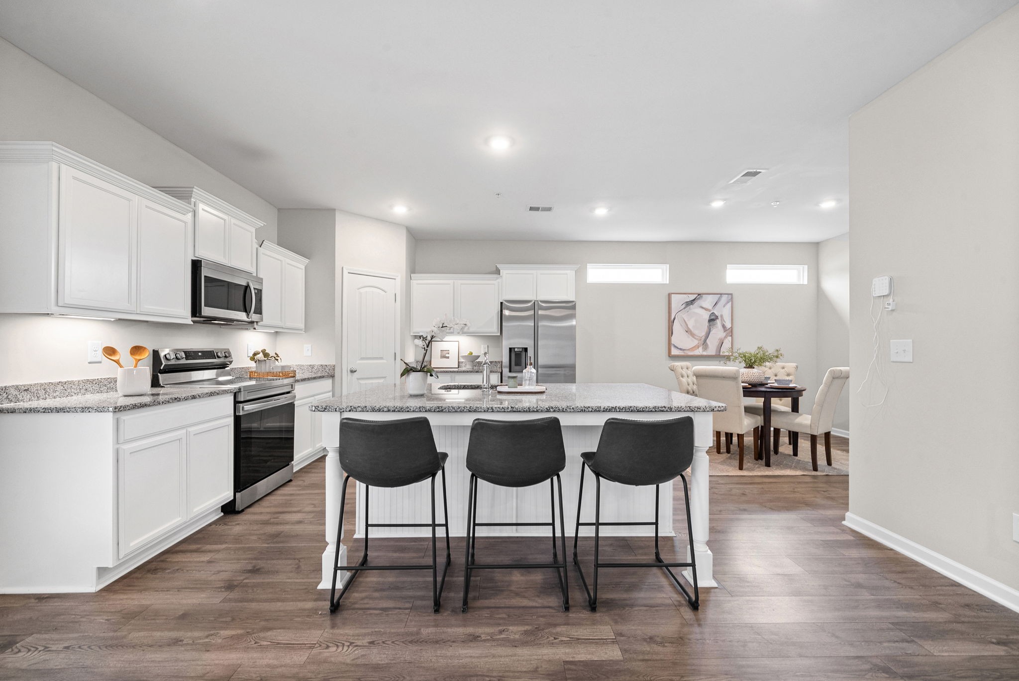 719 Reflections Lane Pleasant View, TN 37146 - Photo 13 of 46 a kitchen with a dining table chairs wooden floor and appliances