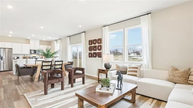 a living room with lots of furniture and view of kitchen