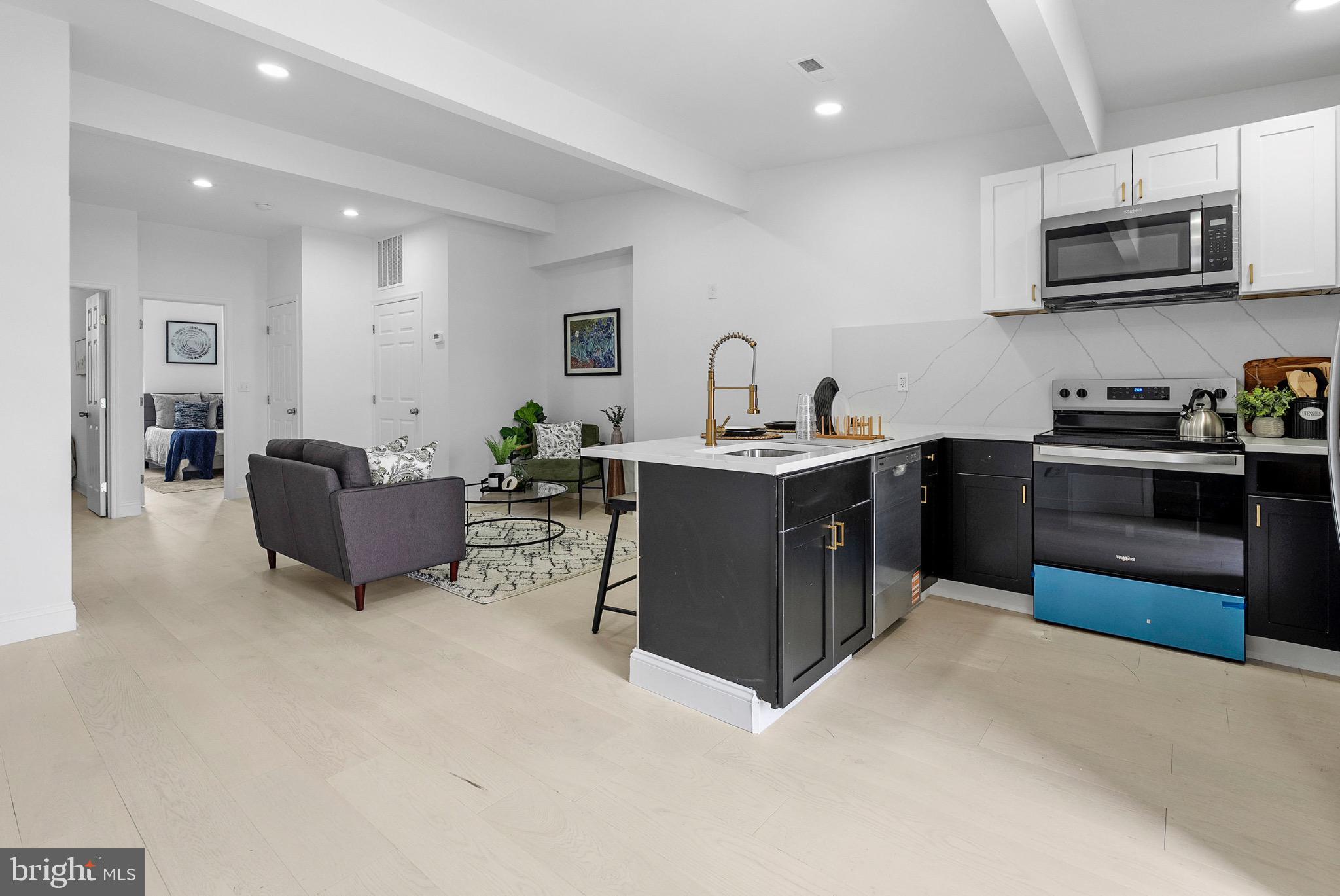 2106 McCulloh Street Baltimore, MD 21217 - Photo 18 of 38 a kitchen with kitchen island stainless steel appliances a sink a counter top space cabinets and a couch