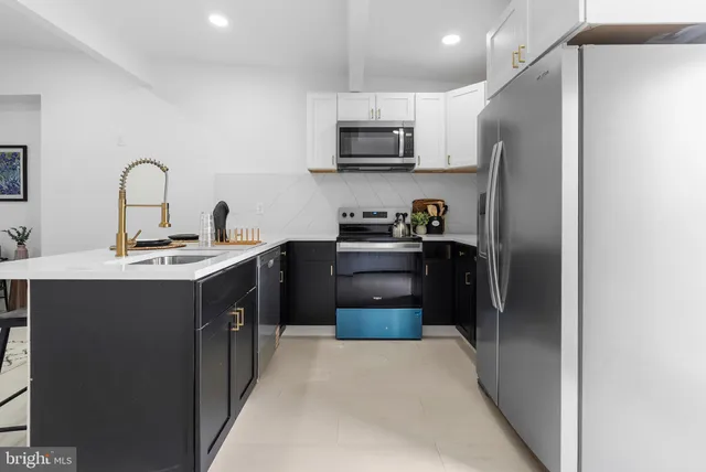 a kitchen with stainless steel appliances a refrigerator sink and microwave