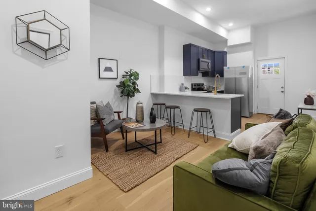 a living room with furniture and a wooden floor