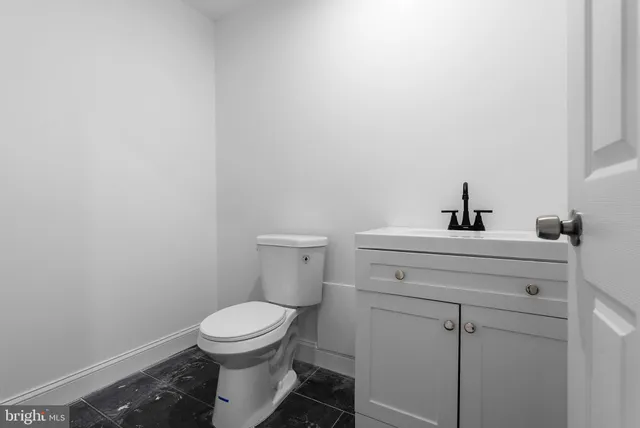 a bathroom with a toilet a sink and mirror