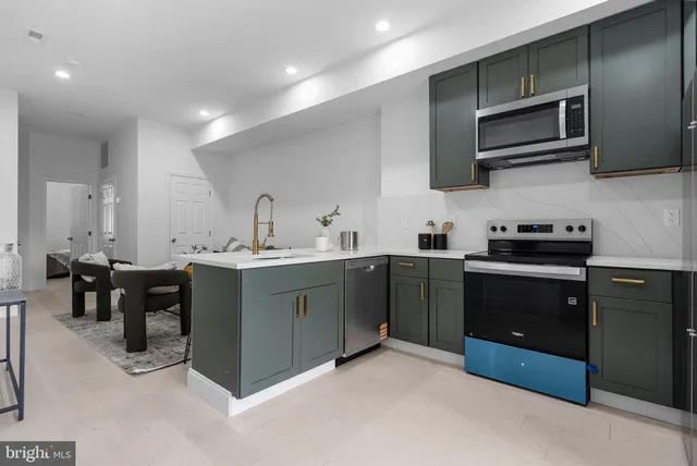 a kitchen with stainless steel appliances granite countertop a sink and stove top oven