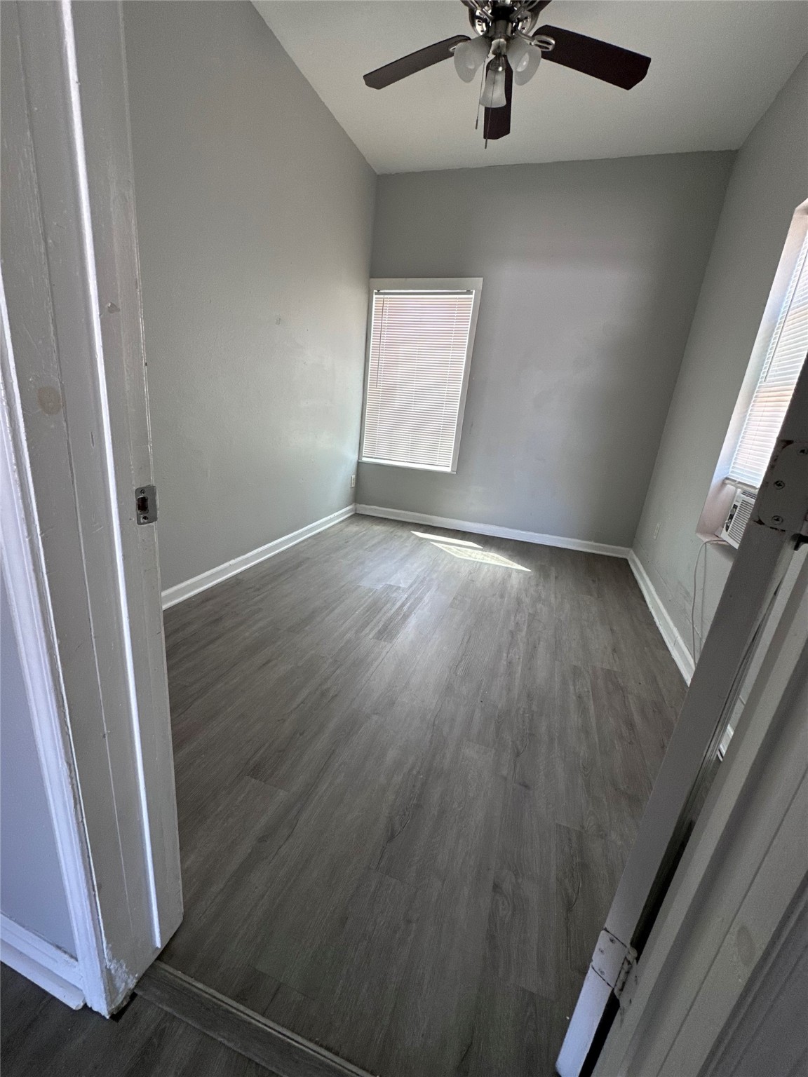 910 37th Street, Unit 3 Galveston, TX 77550 - Photo 11 of 18 an empty room with wooden floor and fan