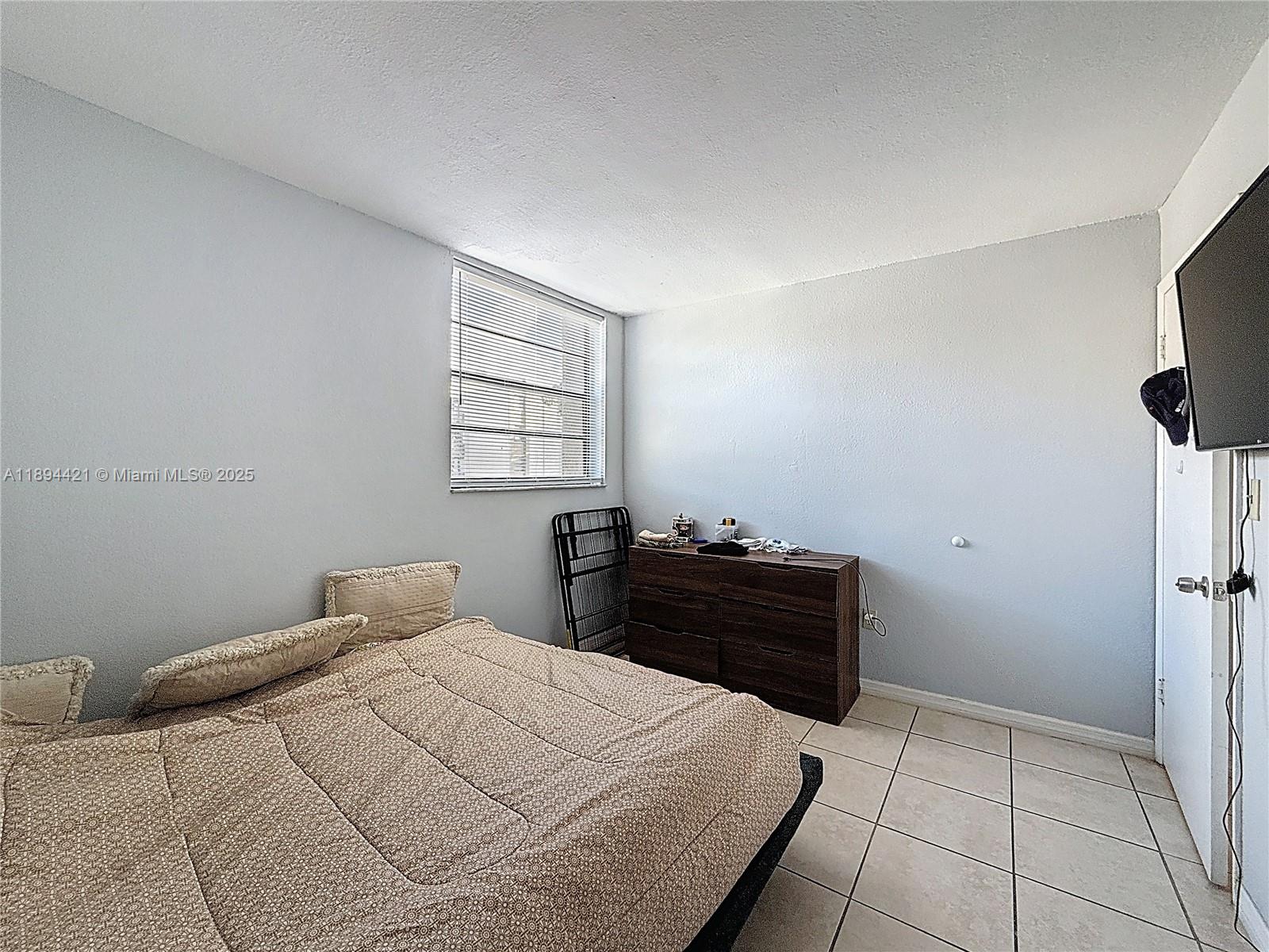 3611 Southwest 117th Avenue, Unit 10207 Miami, FL 33175 - Photo 13 of 35 a bedroom with a bed and window