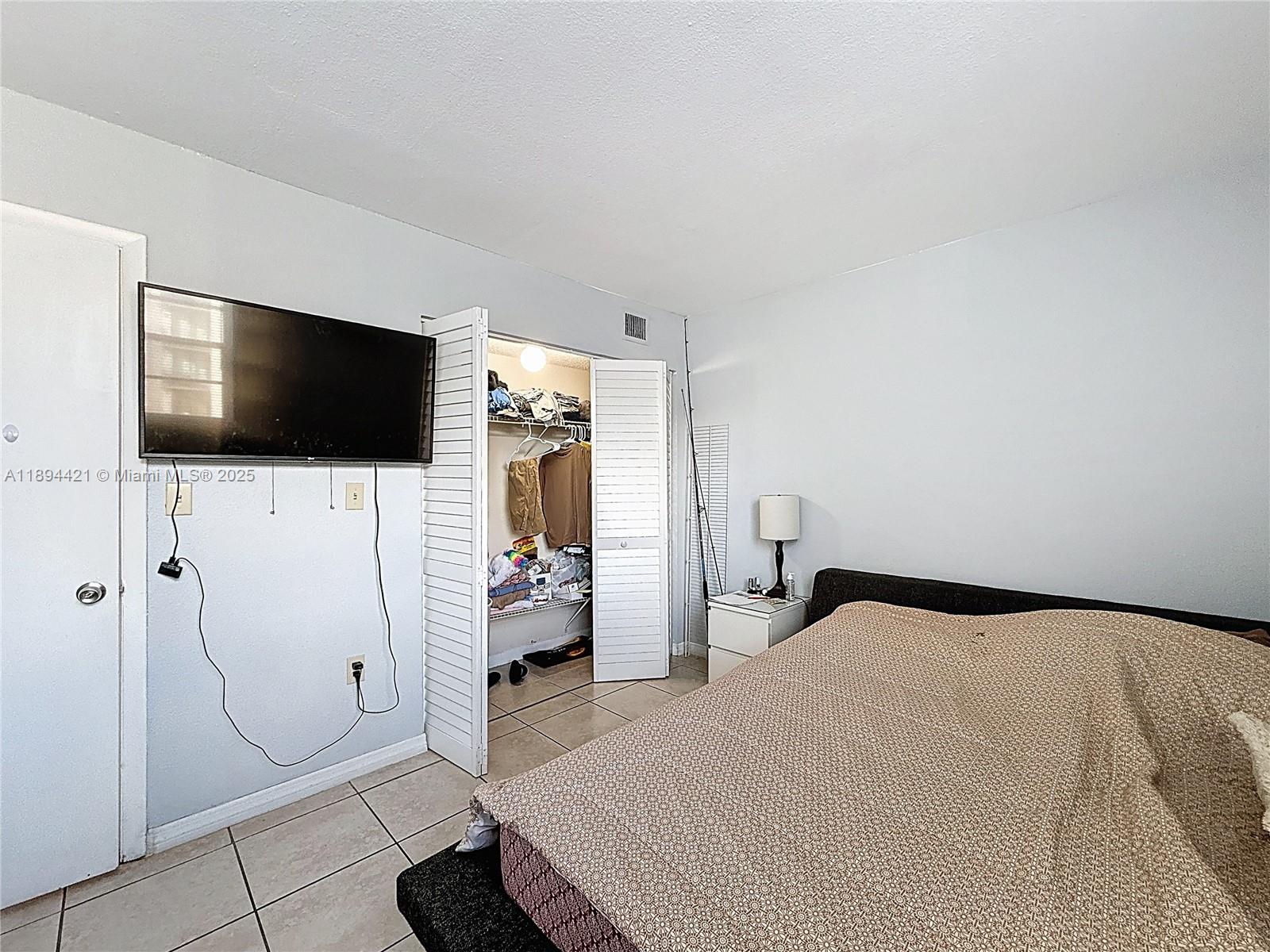 3611 Southwest 117th Avenue, Unit 10207 Miami, FL 33175 - Photo 14 of 35 a bedroom with a bed and a flat screen tv
