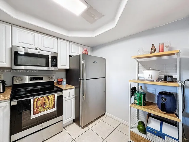 a kitchen with granite countertop a refrigerator and a stove top oven