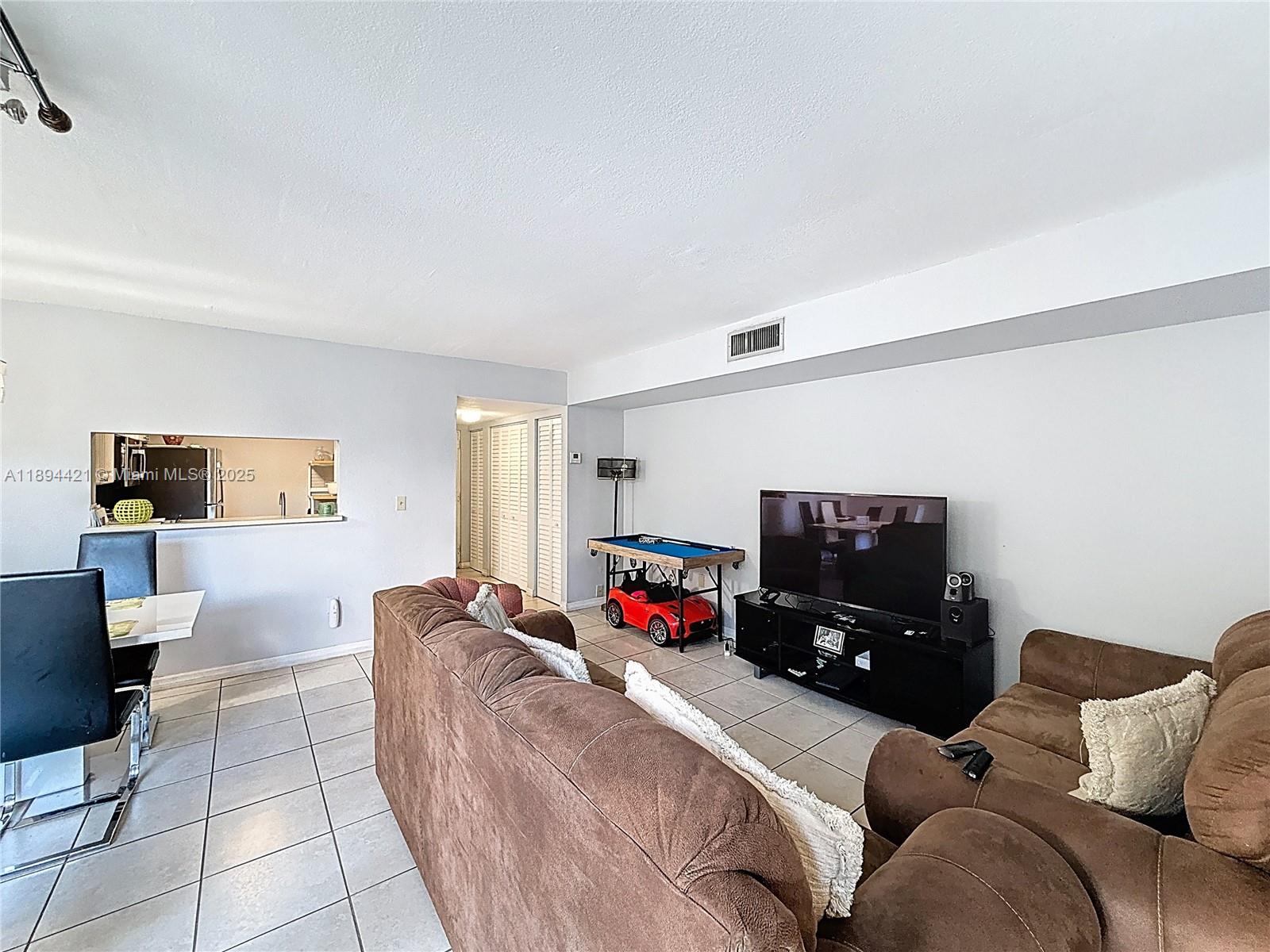 3611 Southwest 117th Avenue, Unit 10207 Miami, FL 33175 - Photo 9 of 35 a living room with furniture and a flat screen tv