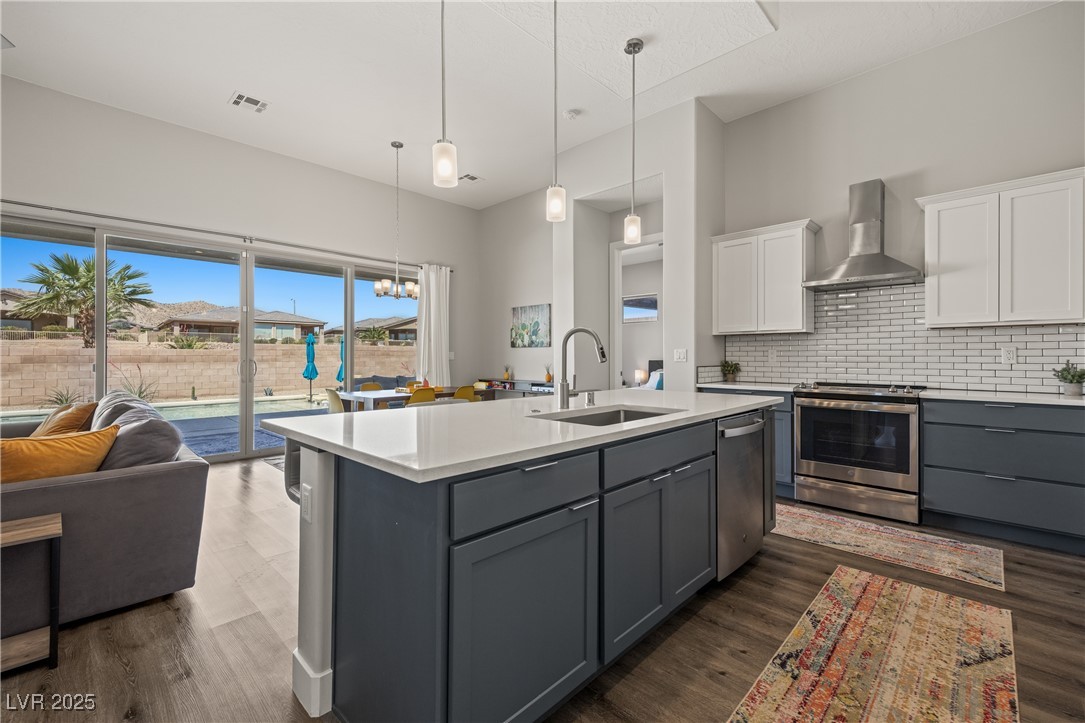 1357 Manassas Ridge Mesquite, NV 89027 - Photo 30 of 72 Kitchen featuring wall chimney range hood, appliances with stainless steel finishes, gray cabinetry, a sink, and white cabinetry