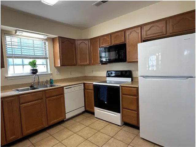 a kitchen with stainless steel appliances granite countertop a refrigerator and a stove top oven