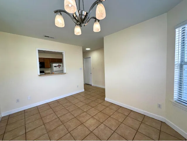 an empty room with a wooden floor and windows