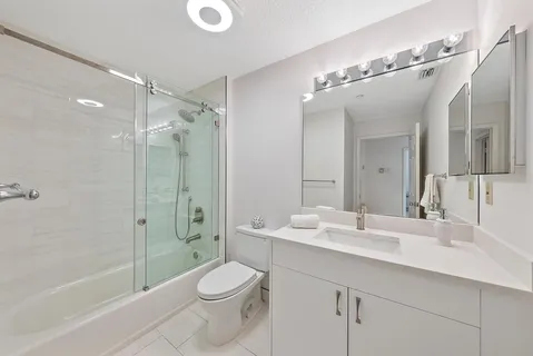 a bathroom with a sink a toilet and shower