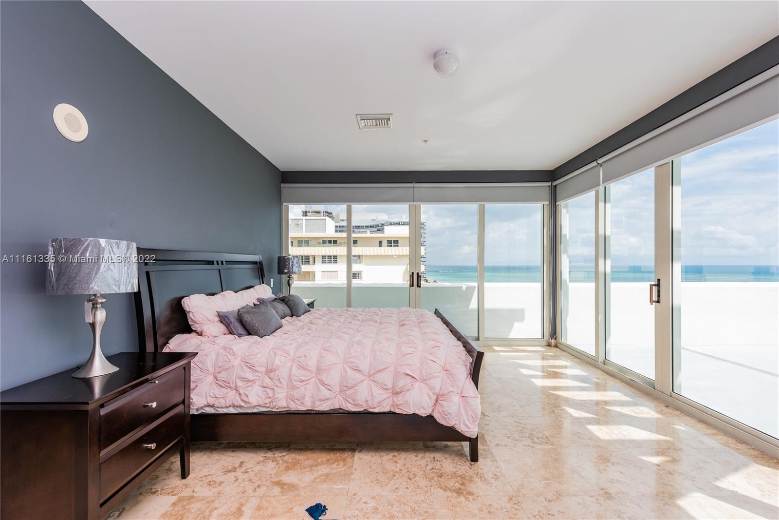 9499 Collins Avenue, Unit PH2 Surfside, FL 33154 - Photo 2 of 38 a bedroom with a large bed and a large window