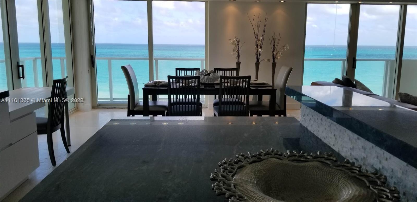 9499 Collins Avenue, Unit PH2 Surfside, FL 33154 - Photo 29 of 38 a dining room with furniture and a floor to ceiling window