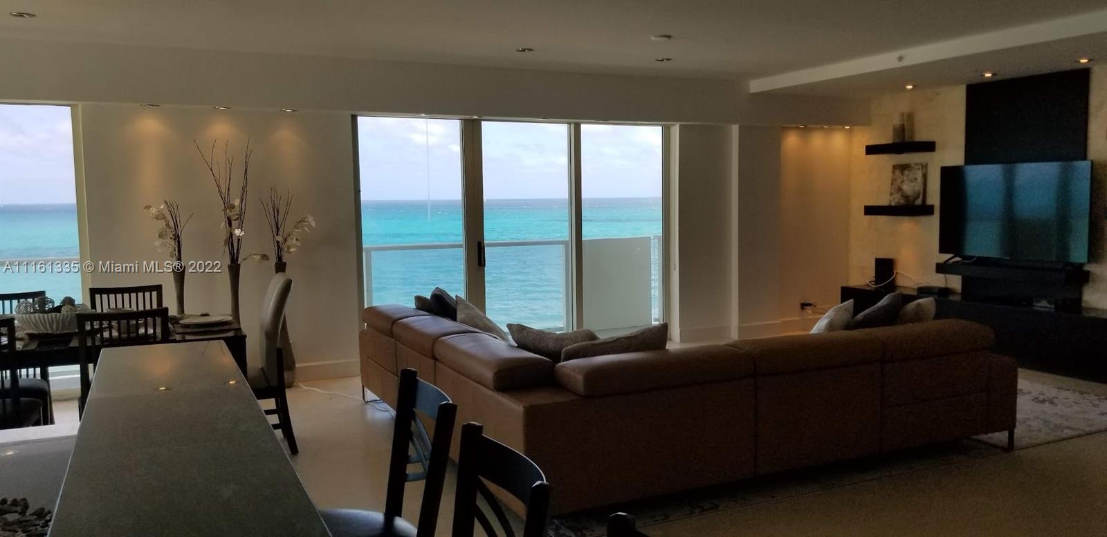 9499 Collins Avenue, Unit PH2 Surfside, FL 33154 - Photo 30 of 38 a living room with furniture tv and a large window