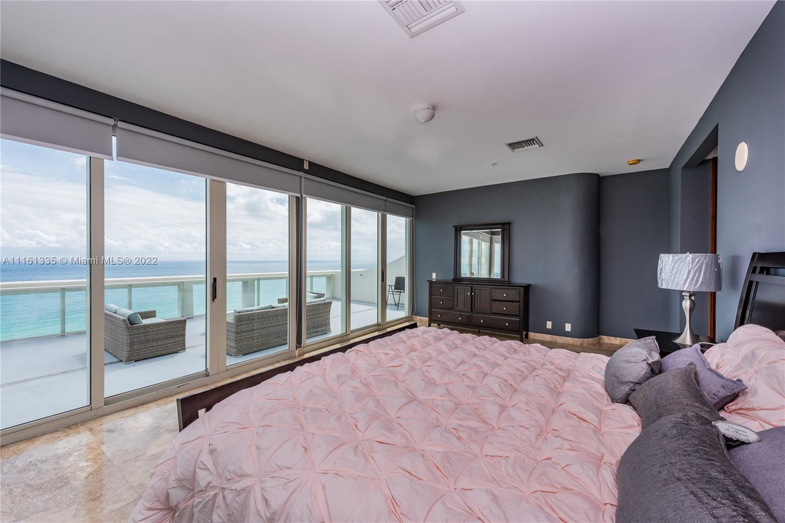 9499 Collins Avenue, Unit PH2 Surfside, FL 33154 - Photo 3 of 38 a large bedroom with a large bed and a large window