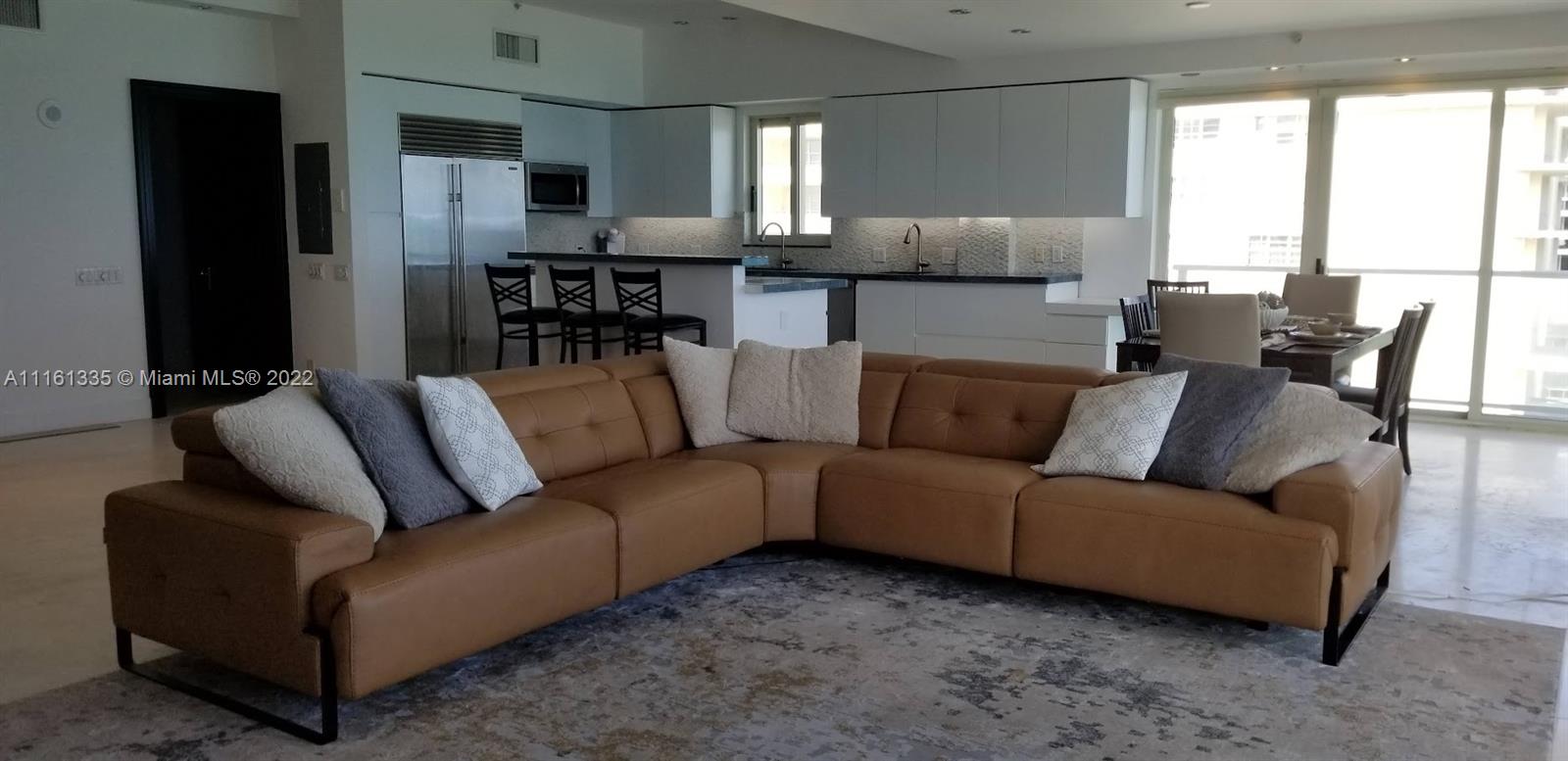 9499 Collins Avenue, Unit PH2 Surfside, FL 33154 - Photo 32 of 38 a living room with furniture and a large window