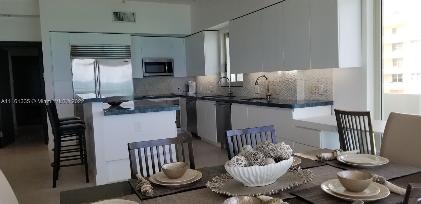 9499 Collins Avenue, Unit PH2 Surfside, FL 33154 - Photo 33 of 38 a dining room with furniture and wooden floor