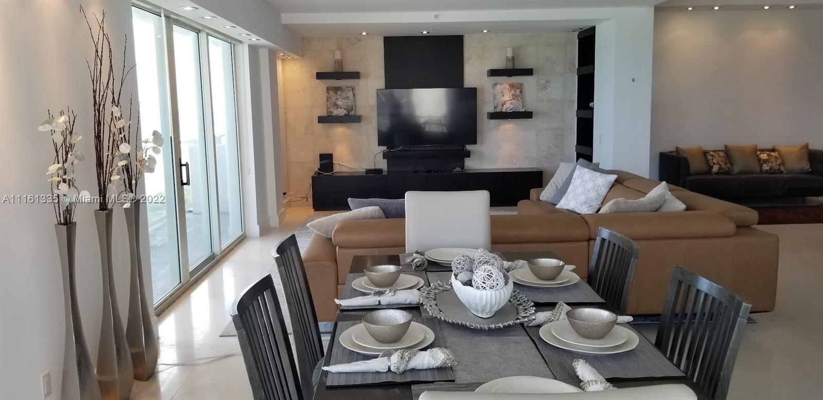 9499 Collins Avenue, Unit PH2 Surfside, FL 33154 - Photo 35 of 38 a living room with furniture and a flat screen tv