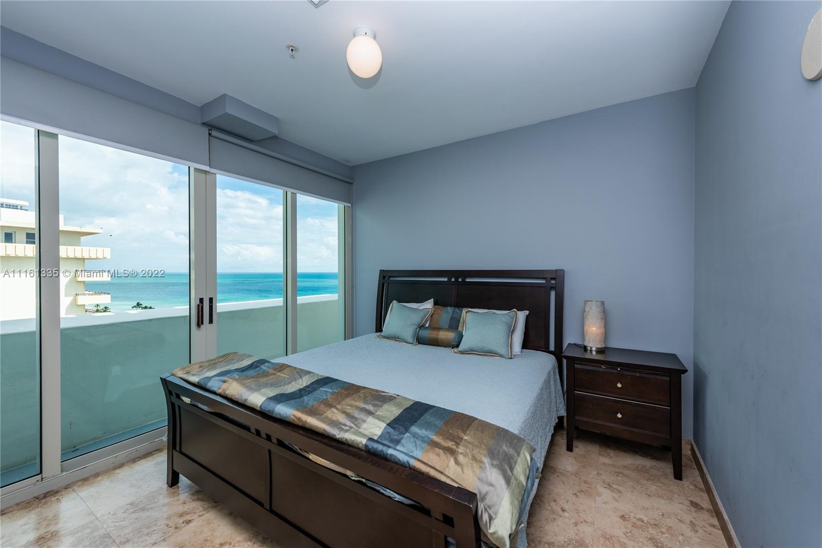 9499 Collins Avenue, Unit PH2 Surfside, FL 33154 - Photo 9 of 38 a bedroom with a bed and a large window