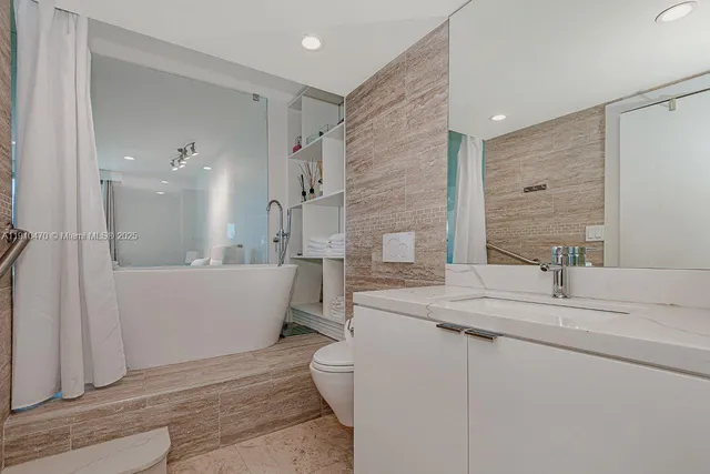 a bathroom with a double vanity sink mirror and bathtub