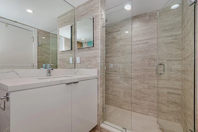 a bathroom with a shower sink and mirror