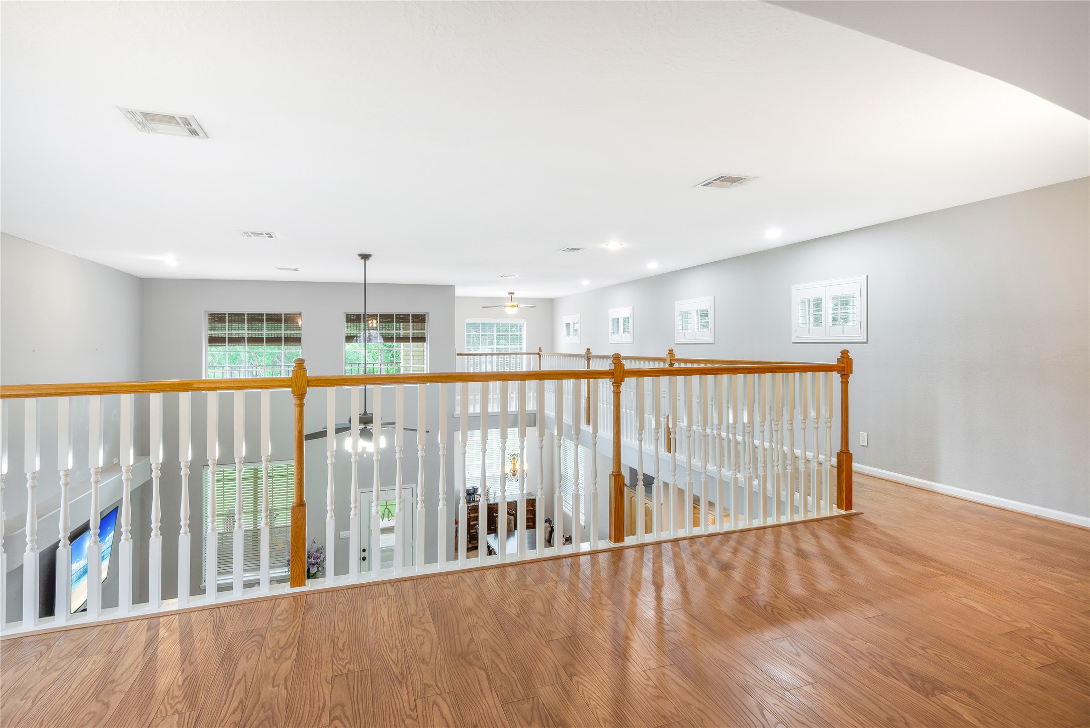 13914 Skinner Road Cypress, TX 77429 - Photo 33 of 50 Mother In Law Suite: Open upstairs landing with hardwood floors and a railing overlooking the main living area.