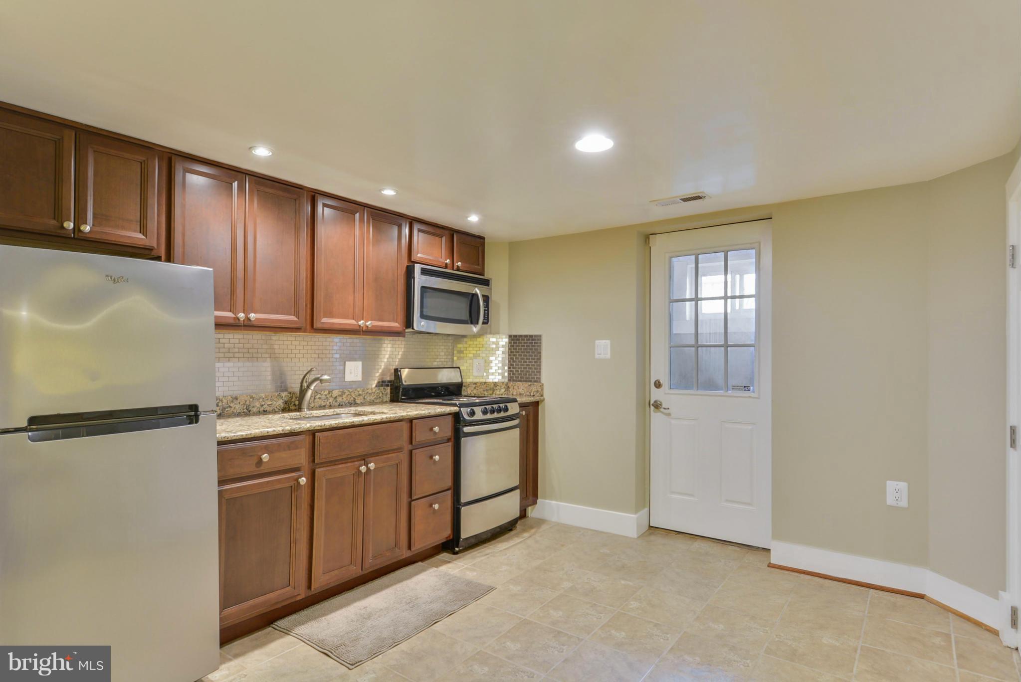 8822 1st Avenue Silver Spring, MD 20910 - Photo 25 of 30 a kitchen with stainless steel appliances granite countertop a refrigerator sink and cabinets