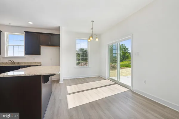 a open kitchen with kitchen island a sink appliances and a large window